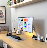 a computer monitor sitting on top of a wooden desk