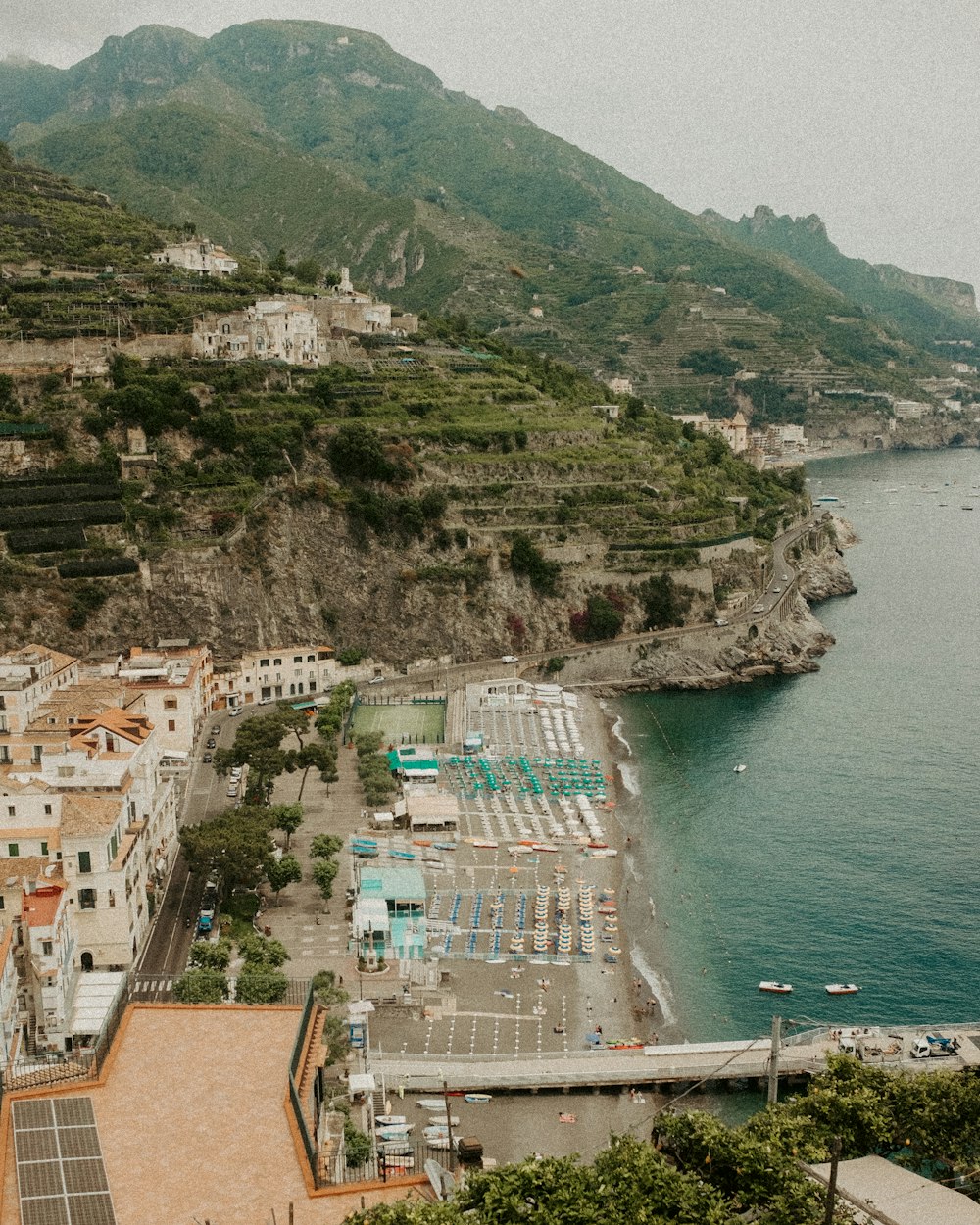 a city next to a body of water with mountains in the background