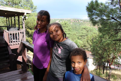 Children playing happily on a wooden deck overlooking the forest at Ecomangos.