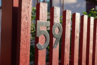 a red fence with a metal number on it