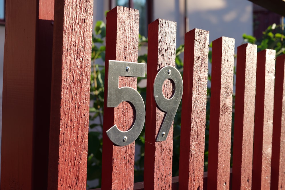 a red fence with a metal number on it