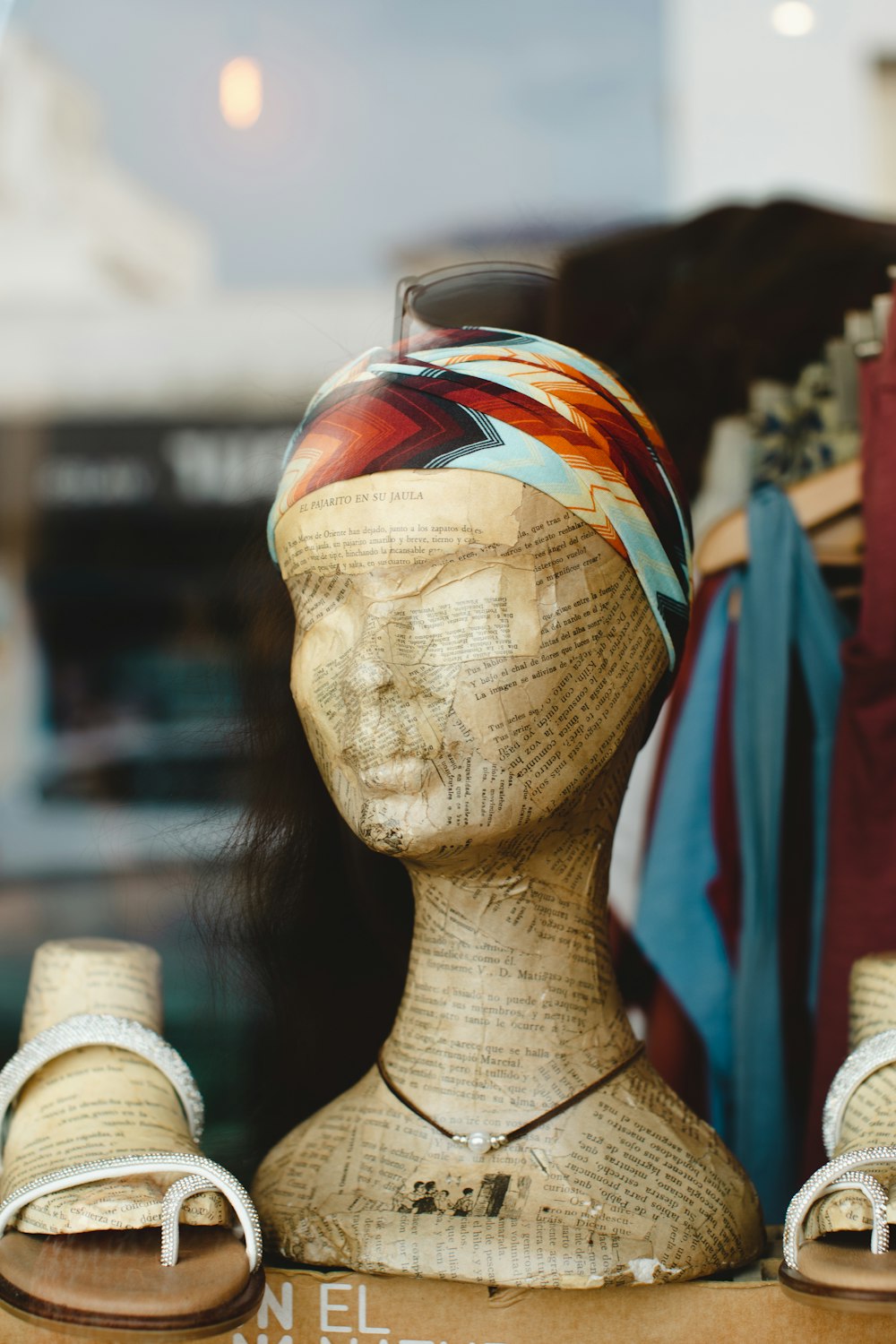 a wooden mannequin with a head scarf on top of it