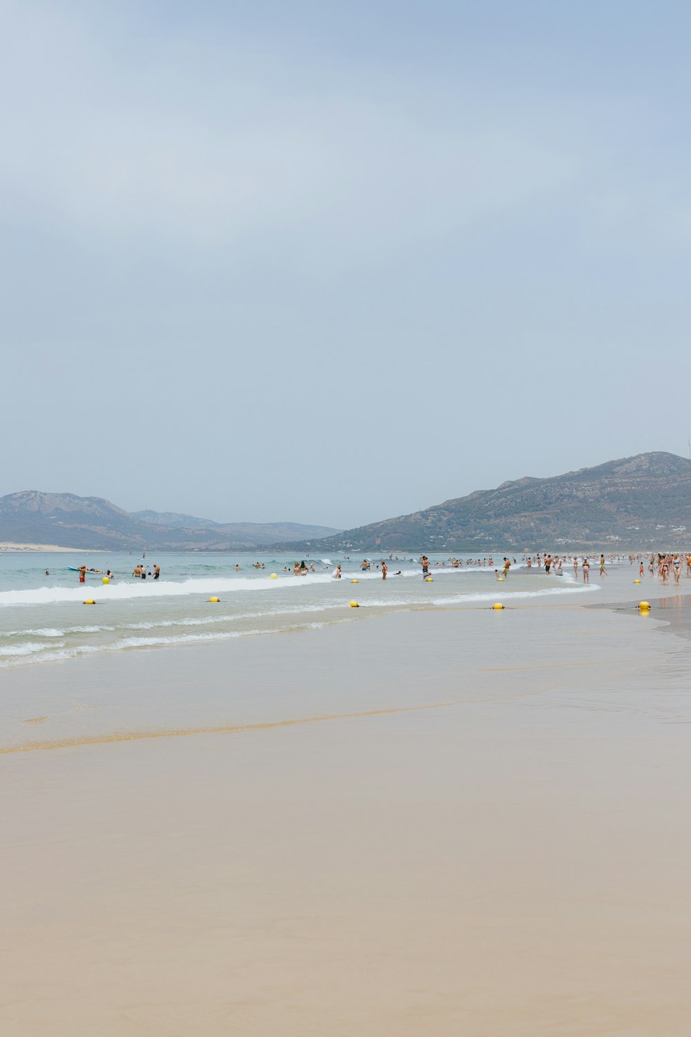 a group of people standing on top of a sandy beach