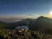 Smiling woman enjoying a mountain view during a sunrise camping trip.