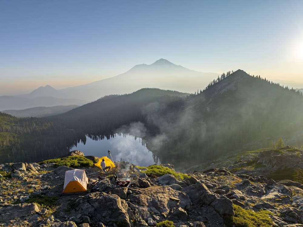 a camp site on a mountain overlooking a lake