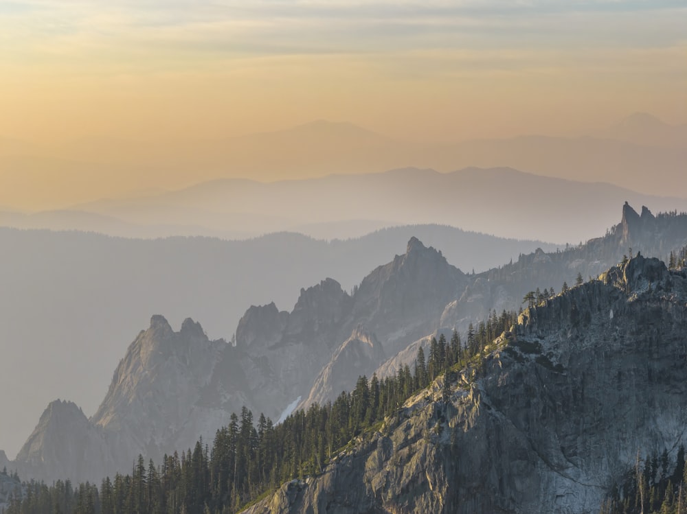 a view of a mountain range with trees in the foreground