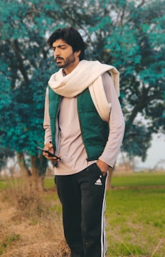 Gary standing in a serene natural setting, holding a tablet with digital data overlay.