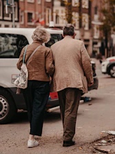 A caring helper sharing a warm moment with an elderly man during a walk in the park.