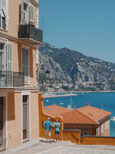 A professional advisor discussing retirement plans with a client overlooking the Mediterranean coast.