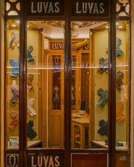 Display of different glove styles hanging on a rustic wall.
