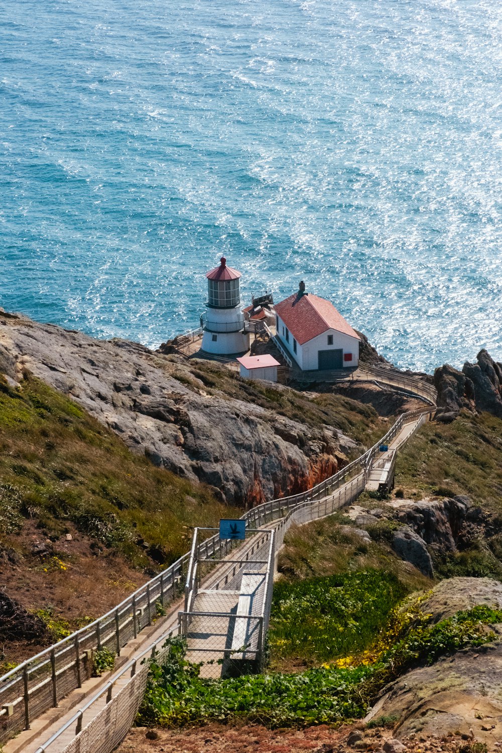 Ein Leuchtturm auf einem Hügel neben dem Meer