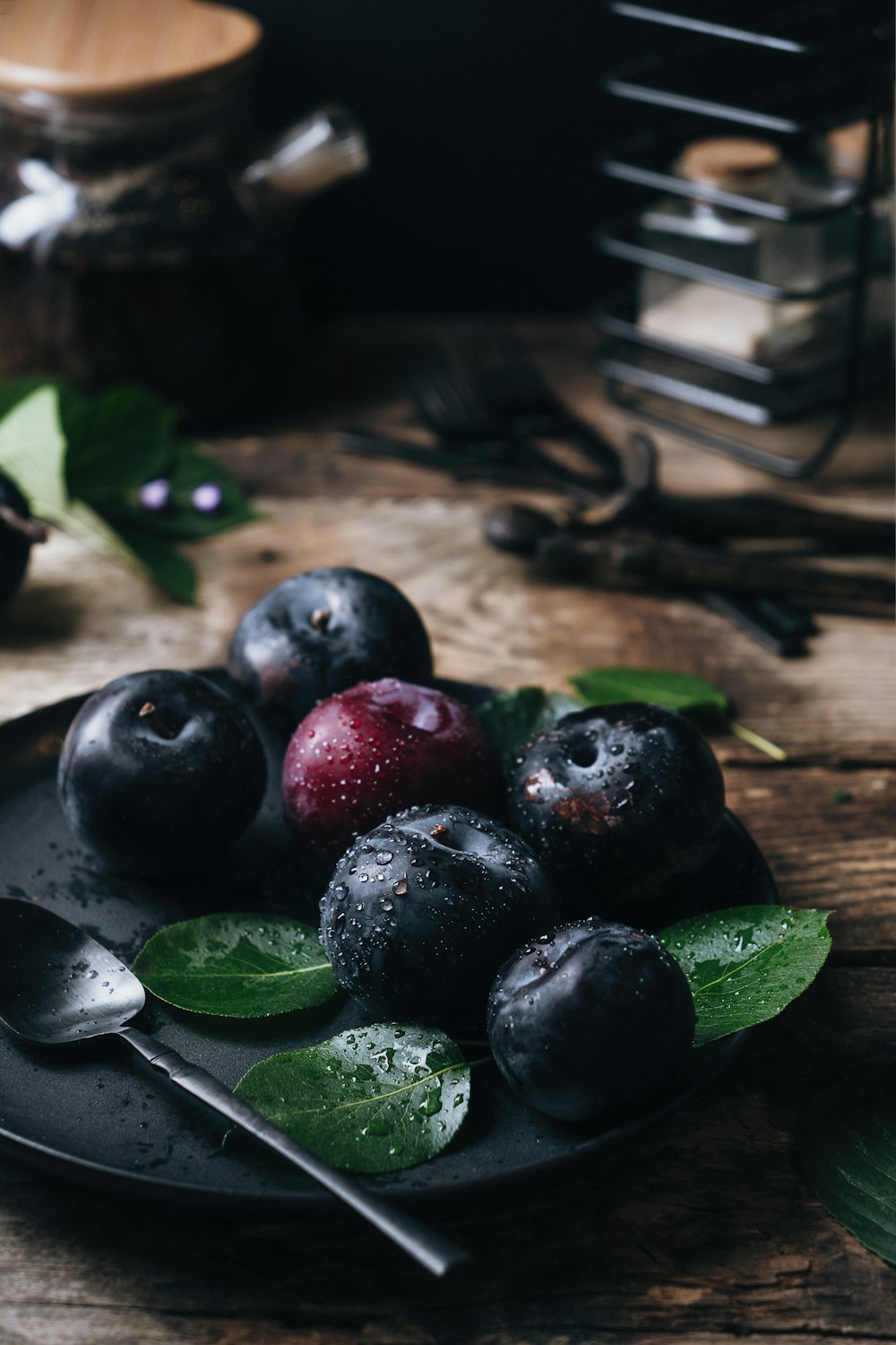 a plate of blueberries and cherries on a wooden table