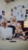 a group of women sitting on top of a bed