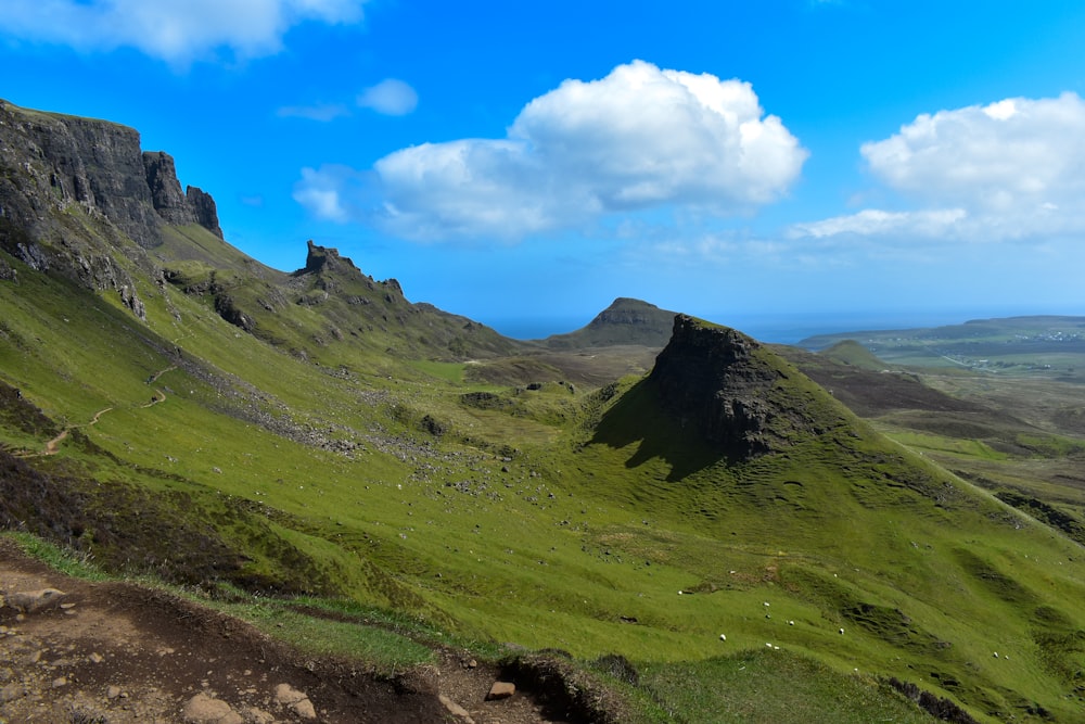 a grassy hill with a few rocks on top of it