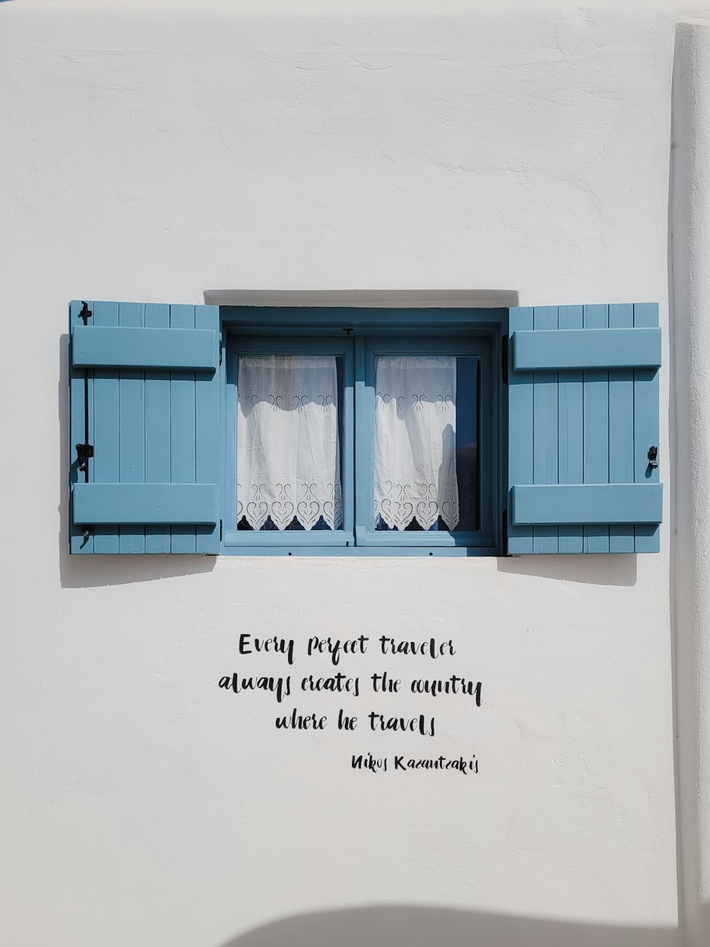 a window with blue shutters and a poem written on it