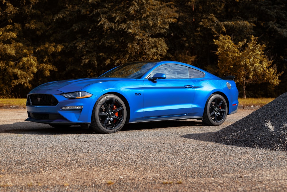 a blue ford mustang parked in a parking lot