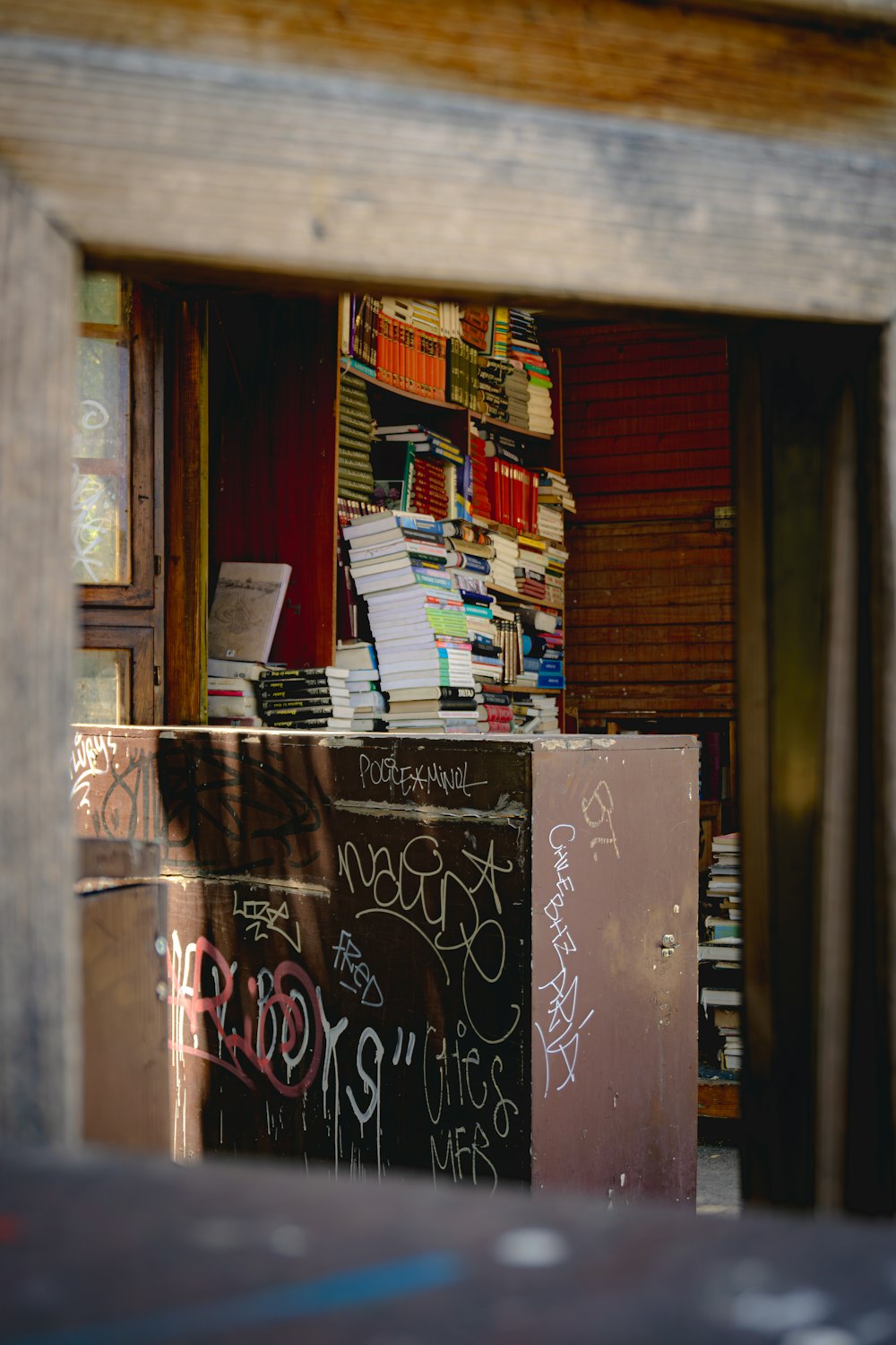 a bookshelf filled with lots of books and graffiti