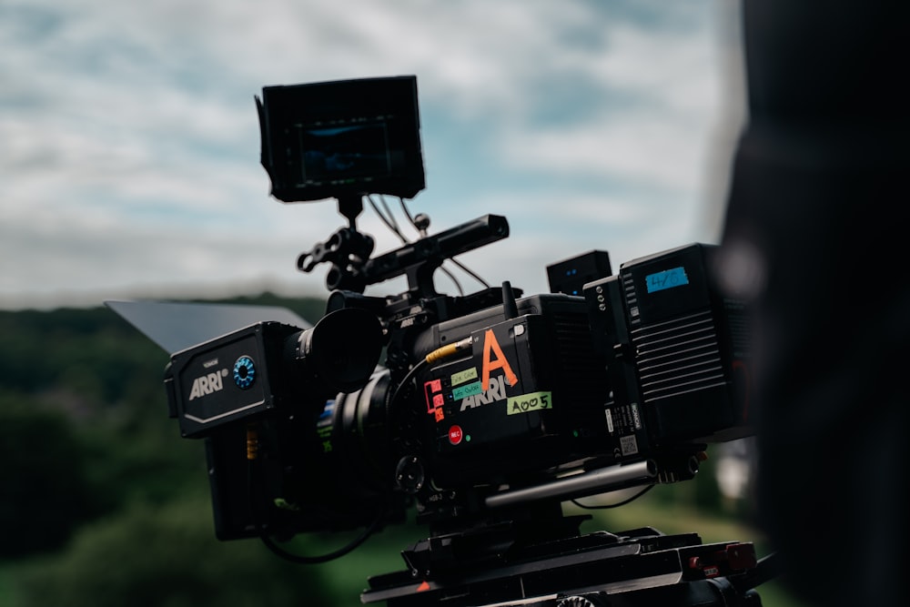 a camera set up on a tripod with a sky background