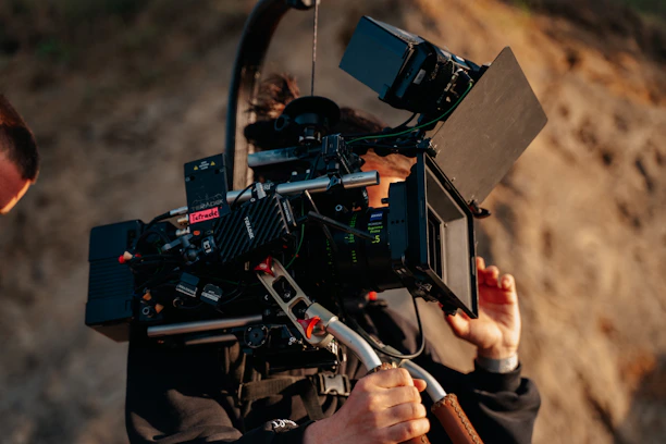 A behind-the-scenes shot of Rian Costa setting up professional camera equipment outdoors.