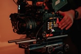 A filmmaker adjusting a camera on a vibrant film set.
