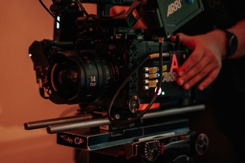 Behind-the-scenes glimpse of a filmmaker adjusting a camera on set.