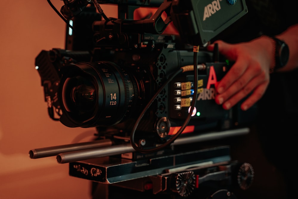 a person holding a camera on top of a tripod