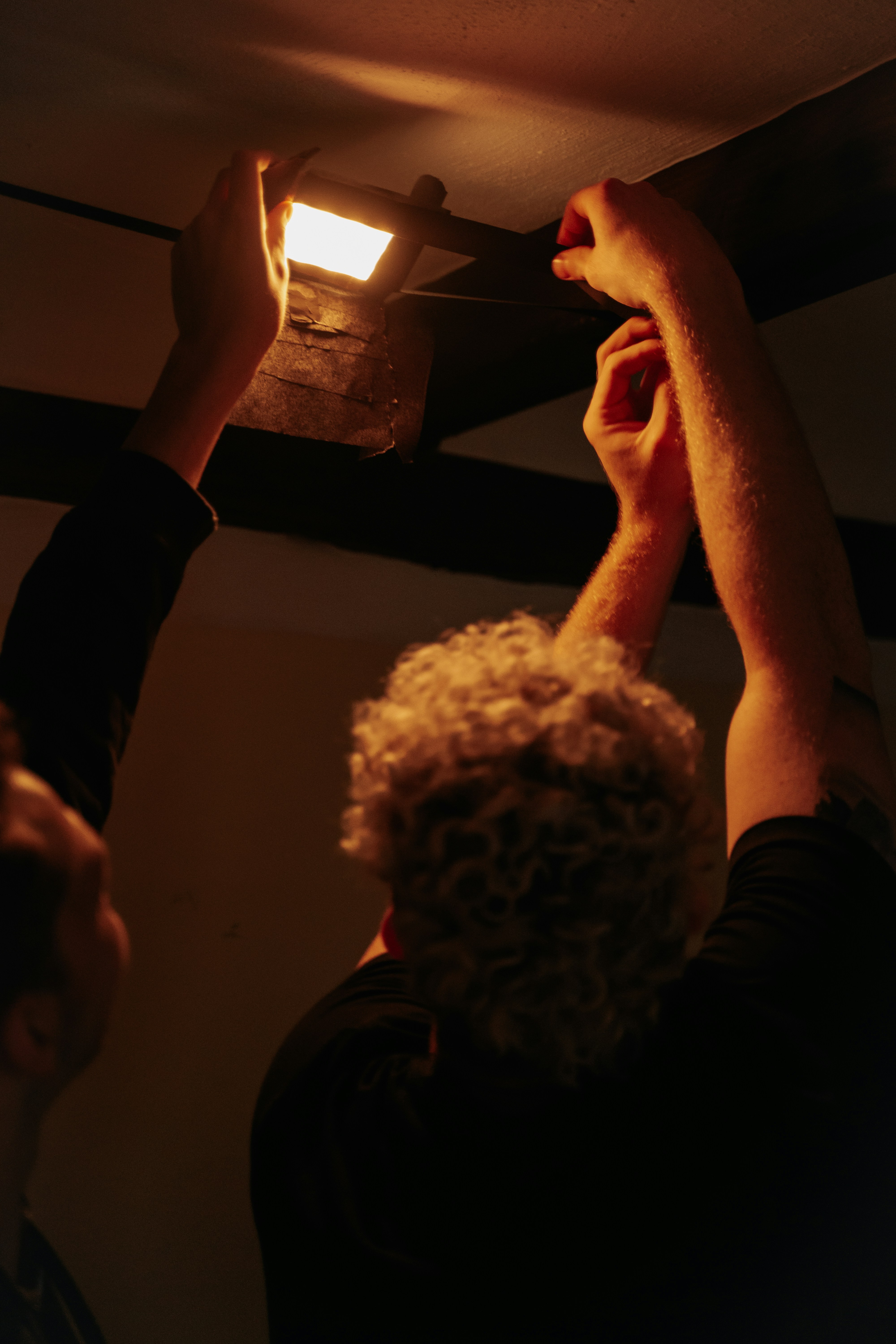a couple of people that are fixing a light