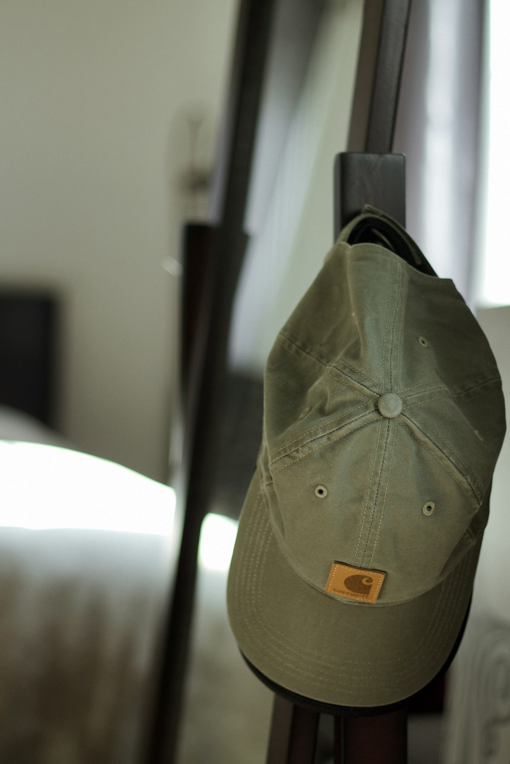 a hat hanging on a rack in a bedroom