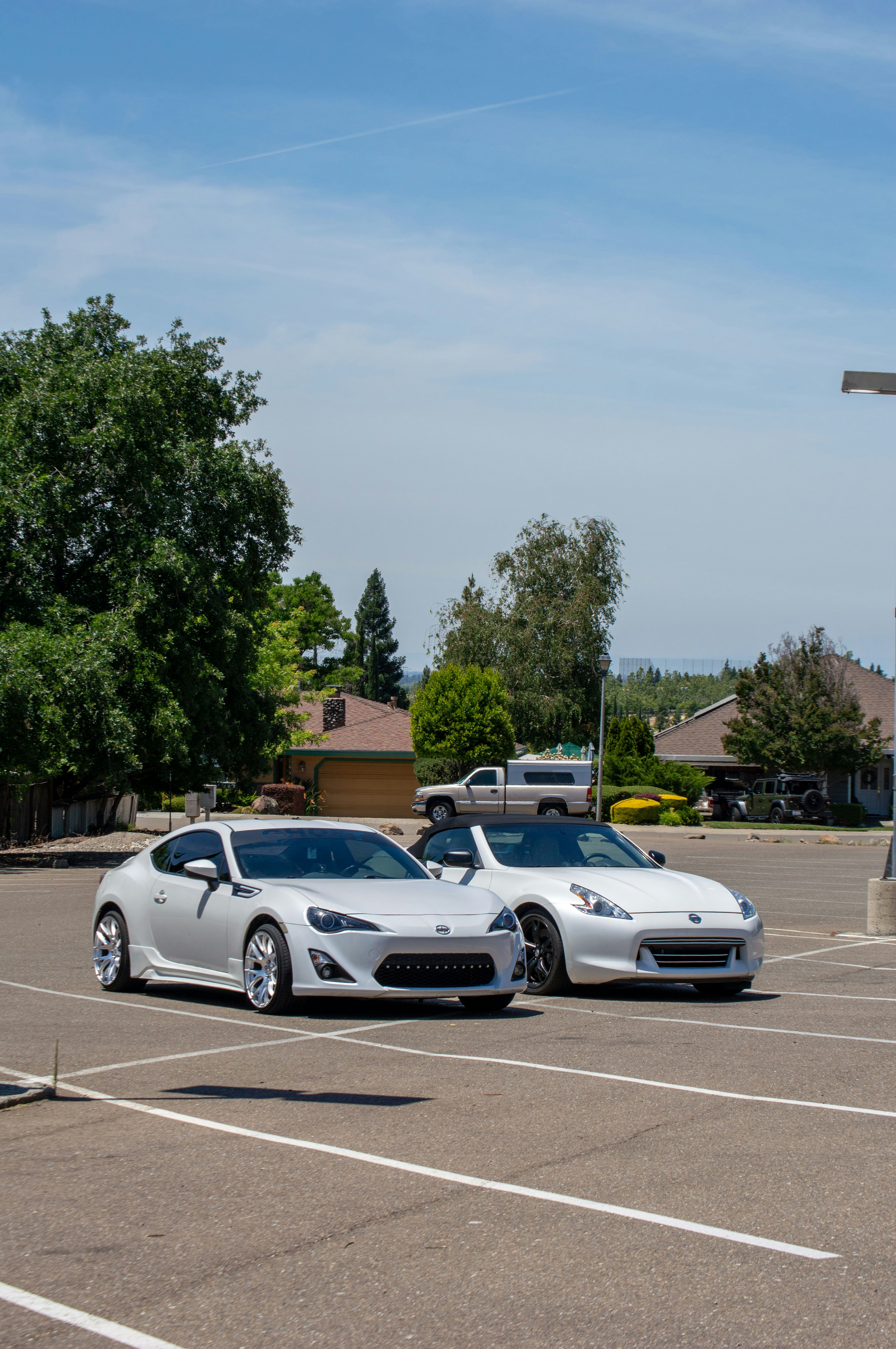 two white sports cars parked in a parking lot