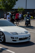 a white sports car parked in a parking lot
