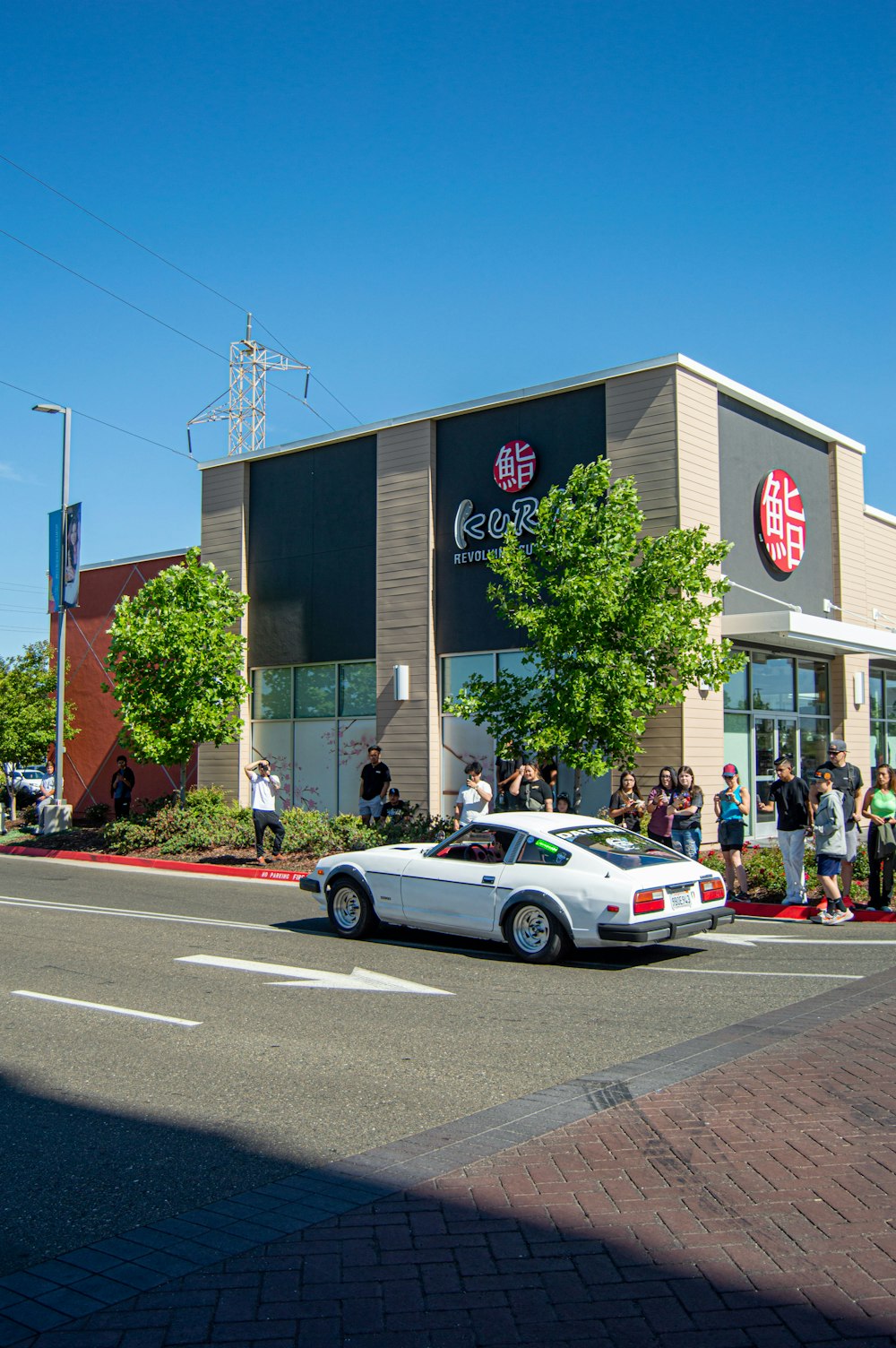 a white car parked in front of a chinese restaurant