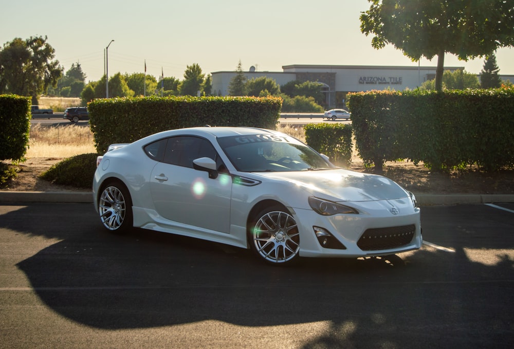 a white sports car parked in a parking lot