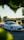 A shiny white Porsche parked in a residential driveway, freshly detailed by a professional technician.
