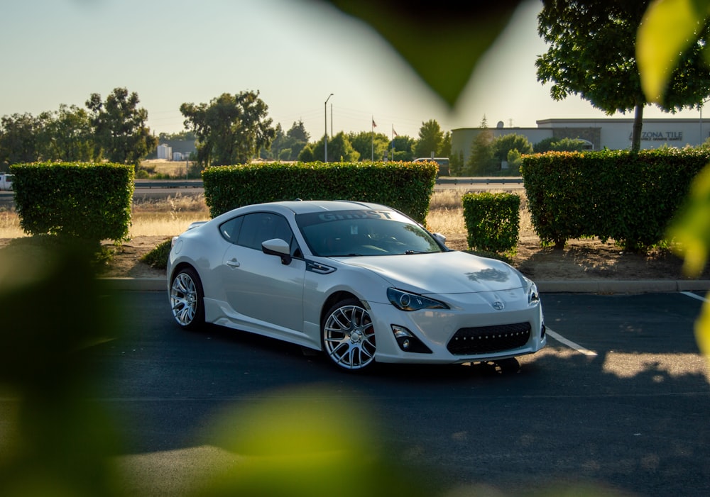 a white sports car parked in a parking lot