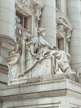 a statue of a woman sitting on top of a building