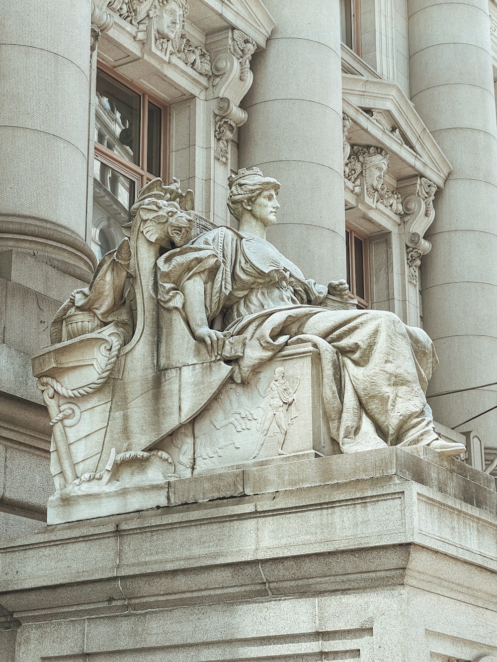 a statue of a woman sitting on top of a building