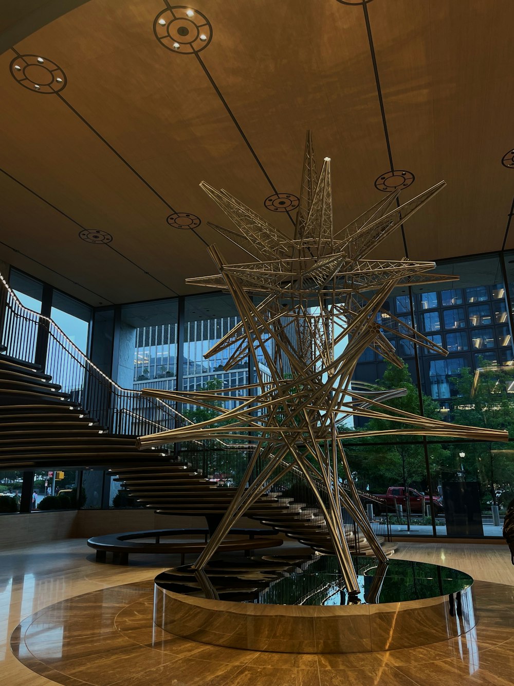a sculpture in a lobby with a staircase in the background