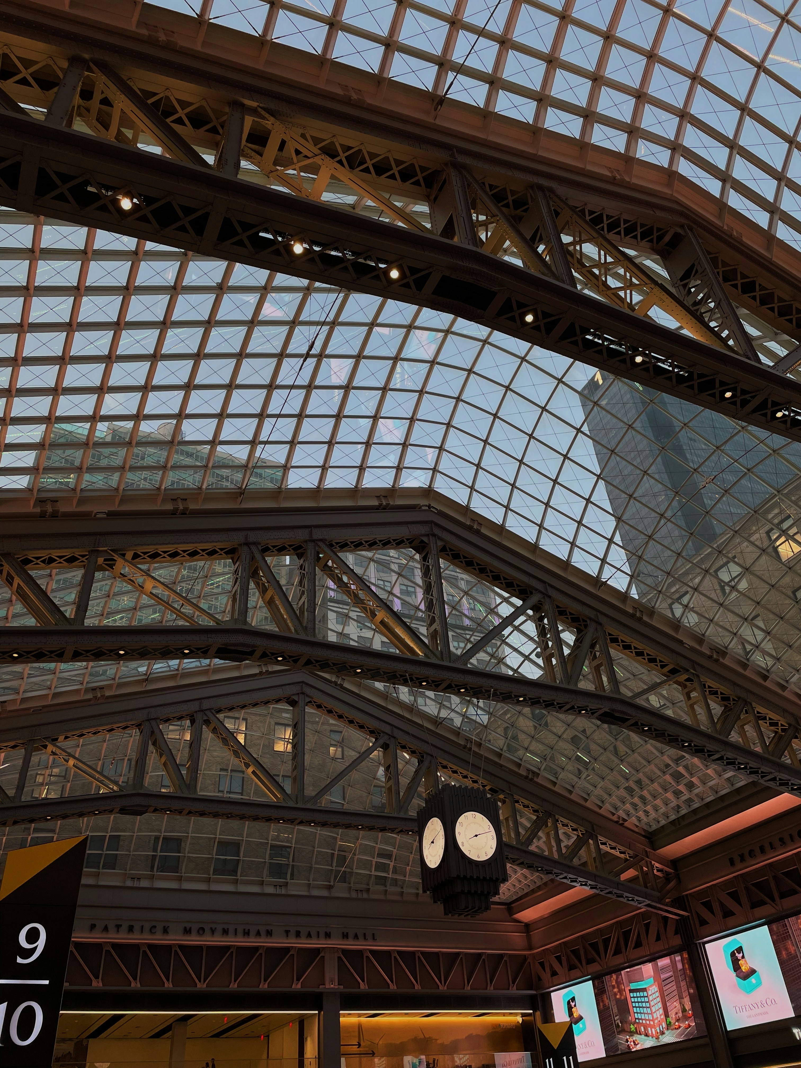 a train station with a clock hanging from the ceiling