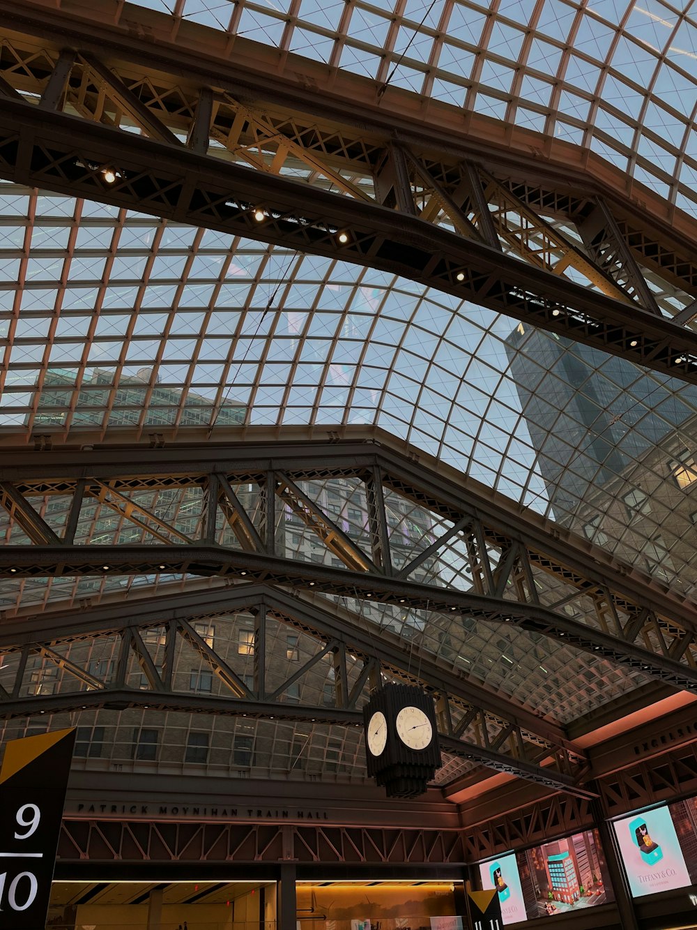 a train station with a clock hanging from the ceiling