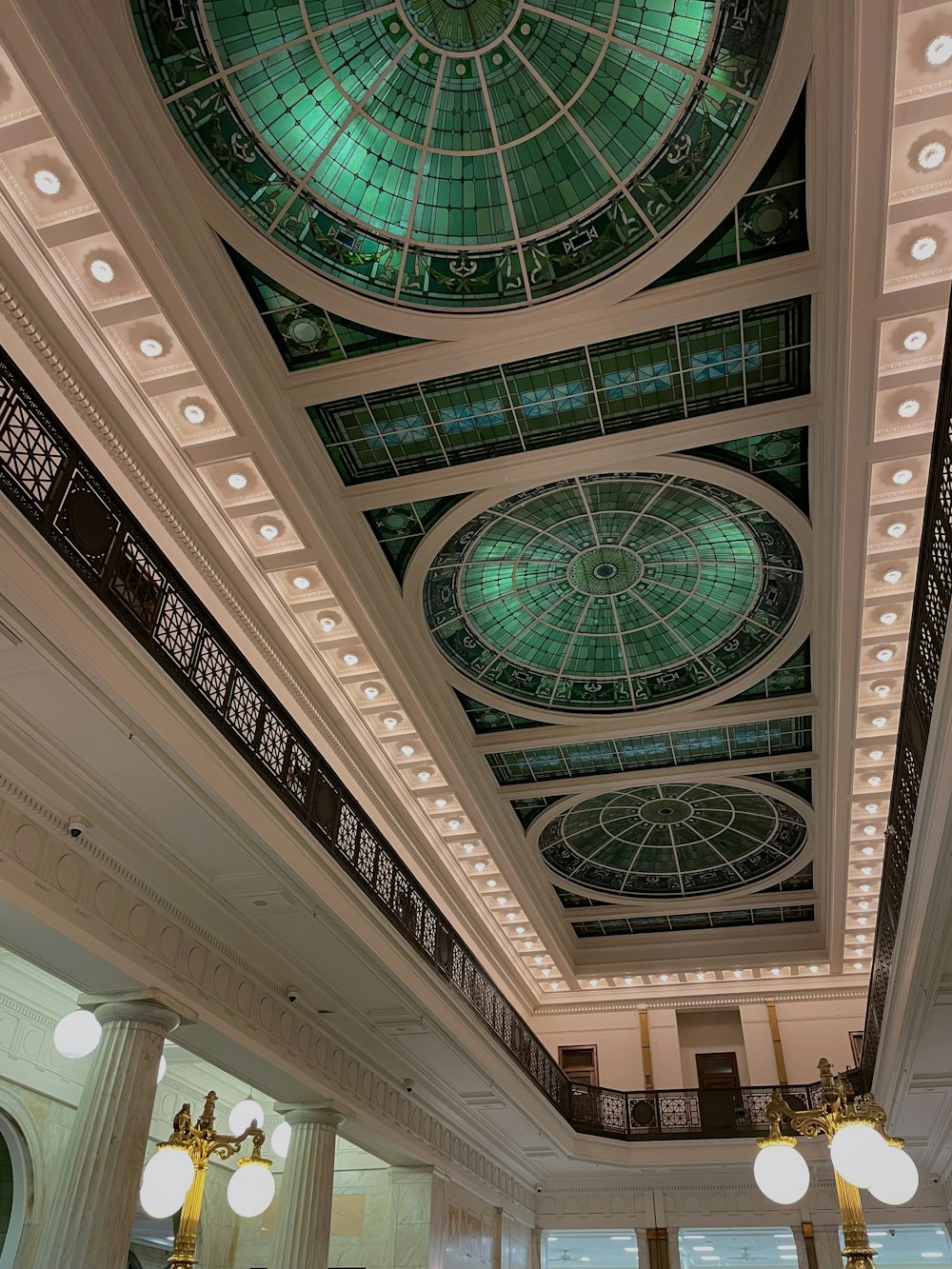 the ceiling of a large building with a green glass dome