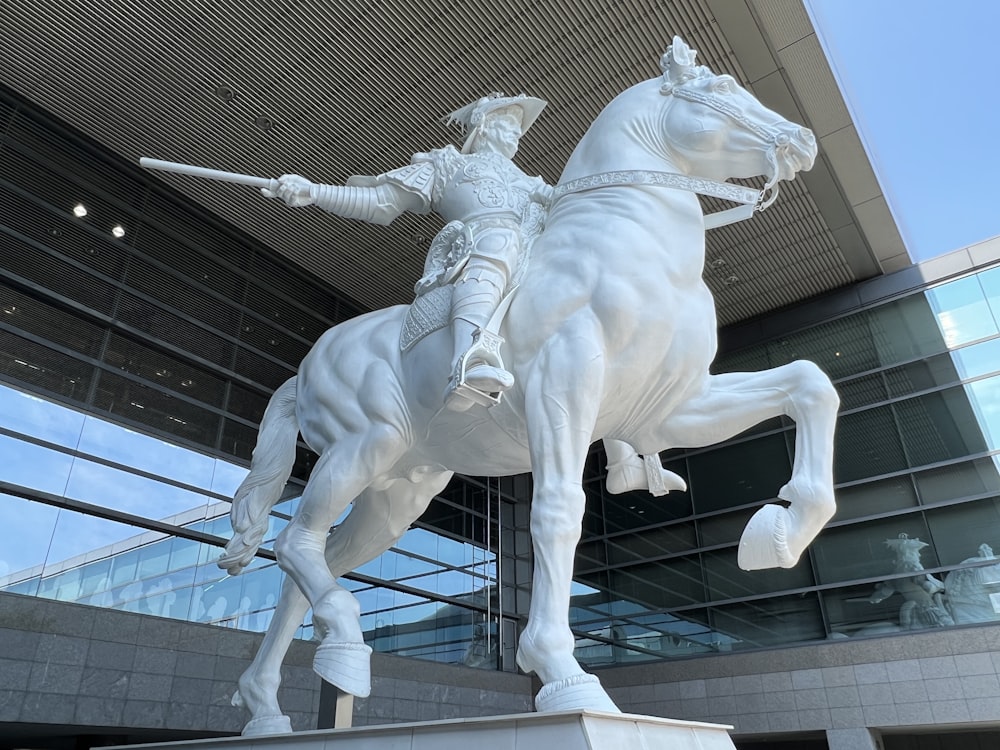 a statue of a man on a horse in front of a building