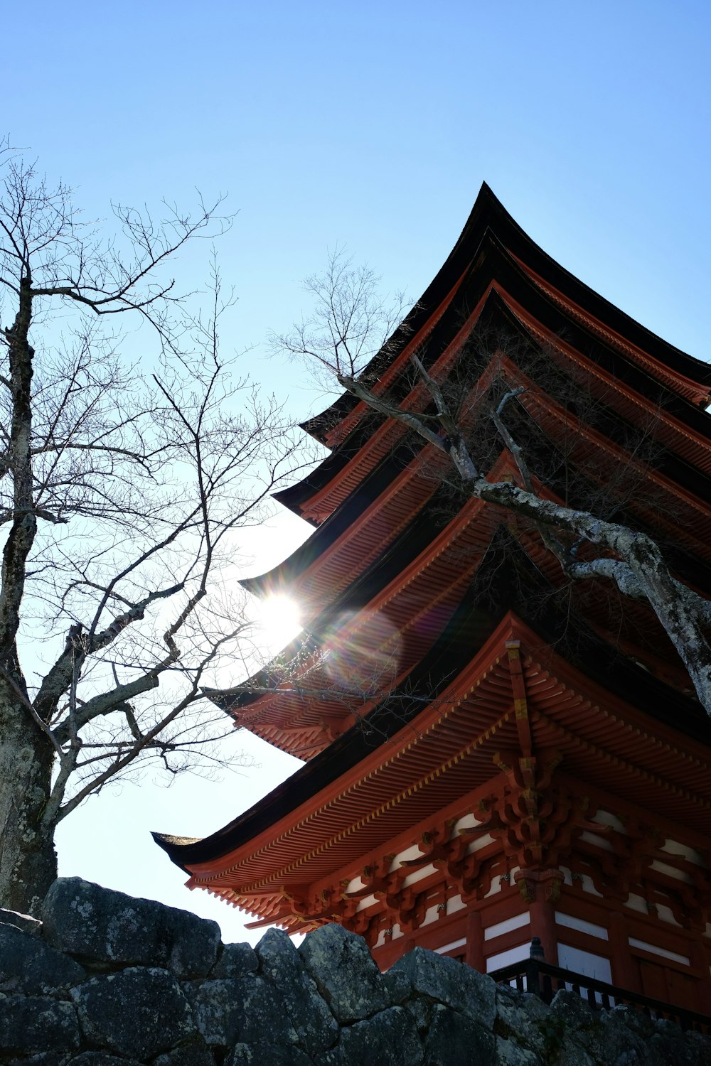 a tall red building sitting next to a tree