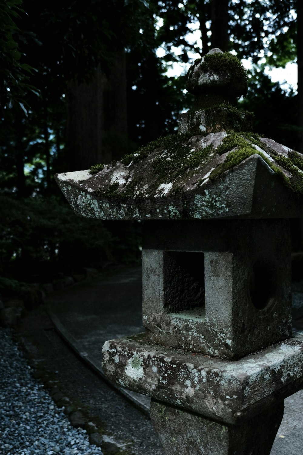 a stone lantern with moss growing on top of it