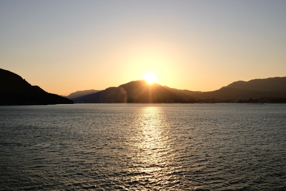 a large body of water with mountains in the background