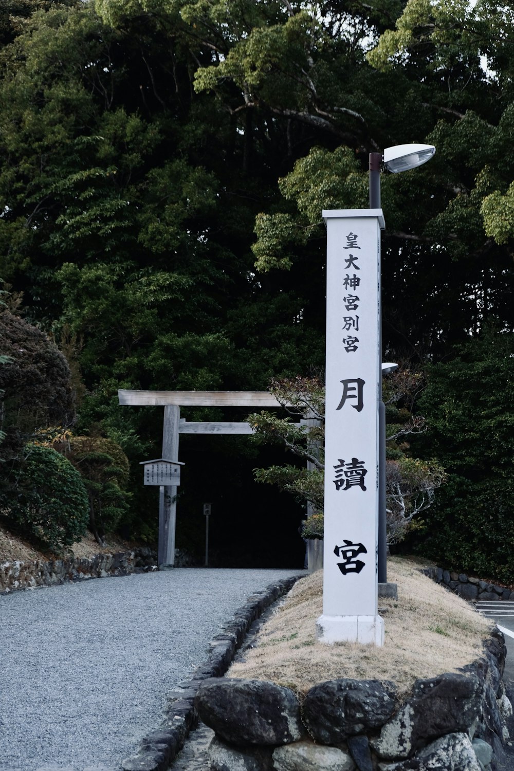 a white and black sign some rocks and trees