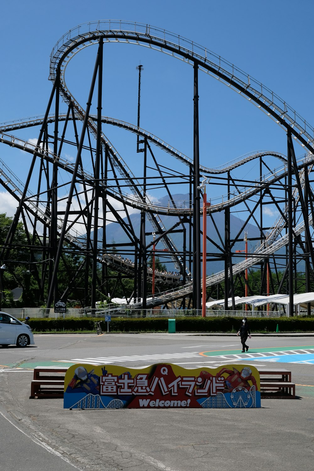 a man riding a skateboard next to a roller coaster