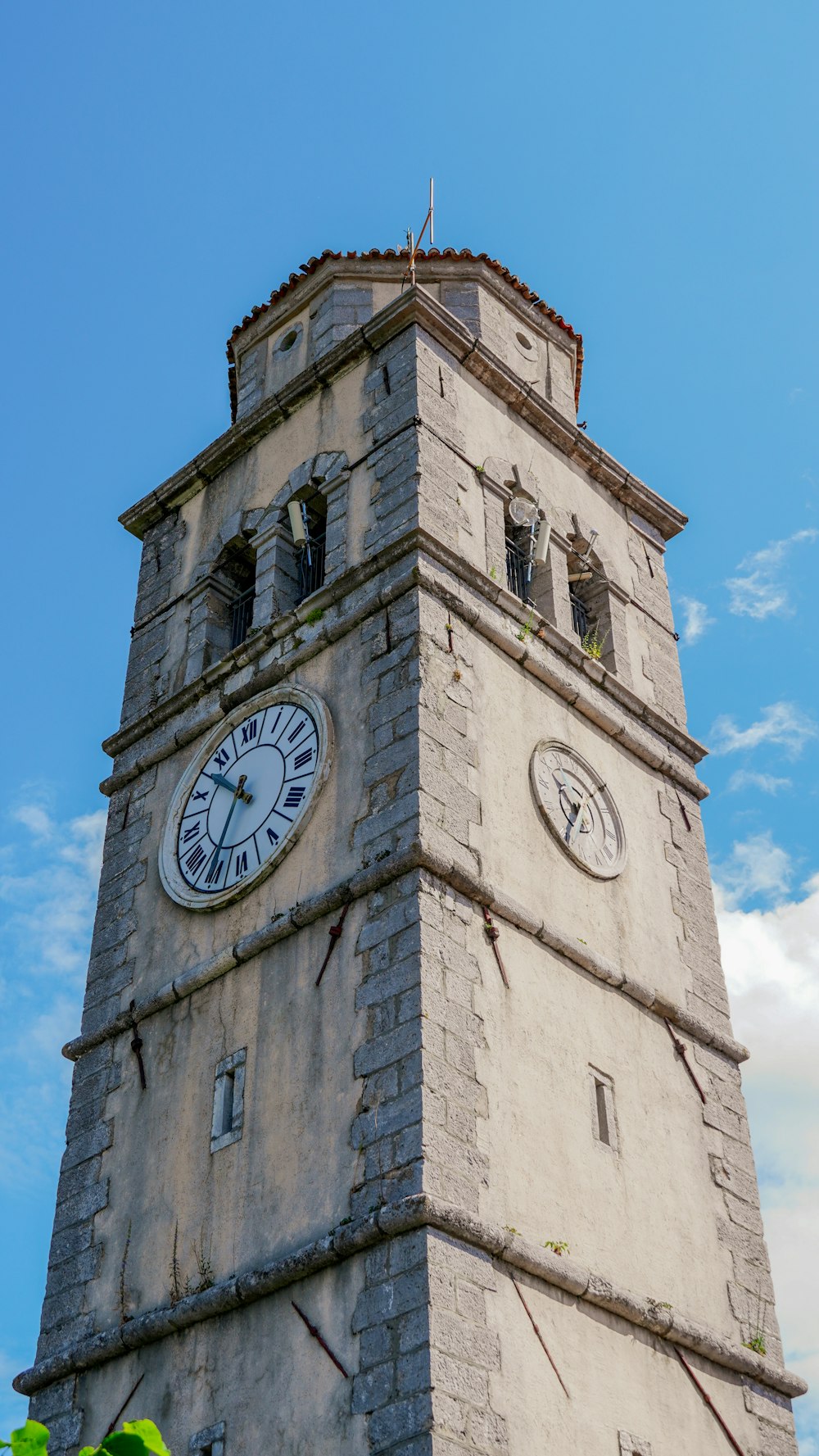 a tall clock tower with two clocks on each of it's sides