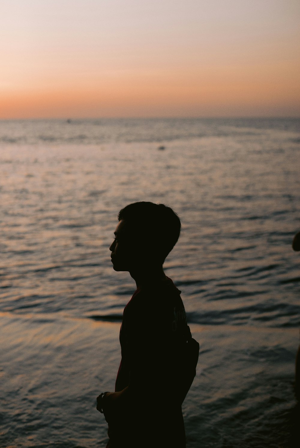 a man standing in front of a body of water