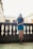 a woman standing on a balcony next to a railing