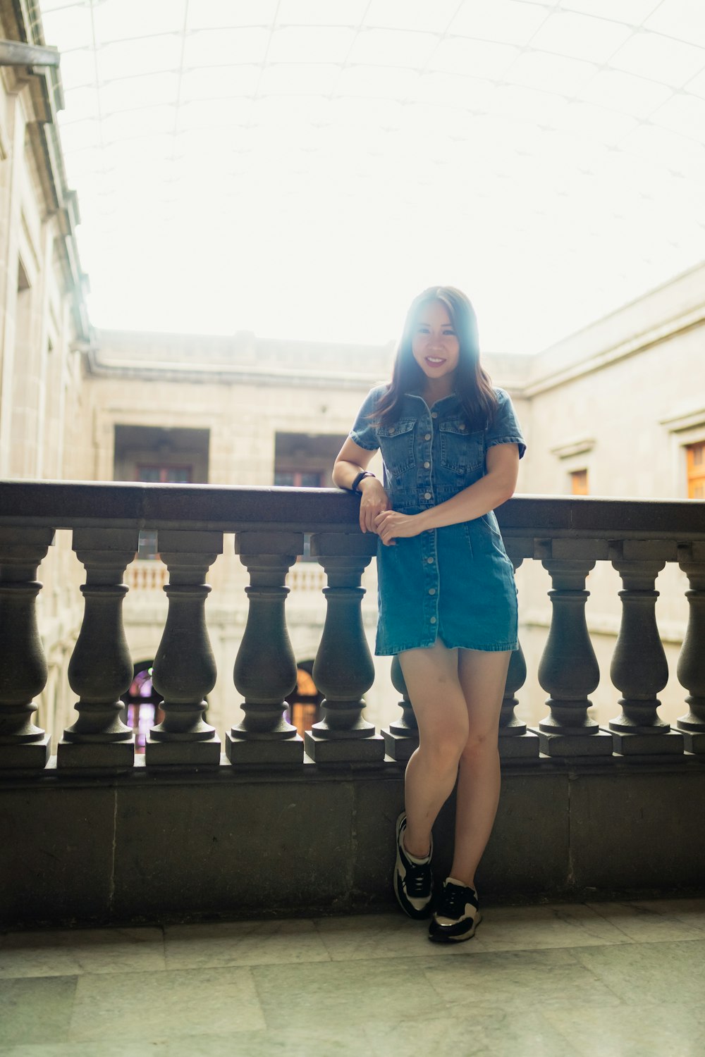 a woman standing on a balcony next to a railing